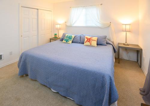a bedroom with a blue bed with two pillows at Karr Beach House on 5th in Seaside