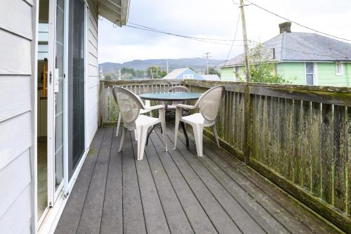 a patio with a table and chairs on a deck at Karr Beach House on 5th in Seaside