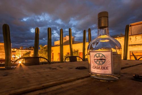 a bottle of alcohol sitting on a wooden table at Casa Olié in Oaxaca City