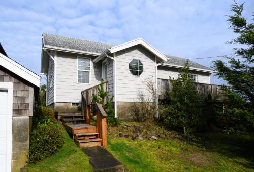 a white house with a wooden staircase in front of it at Karr Beach House on 5th in Seaside