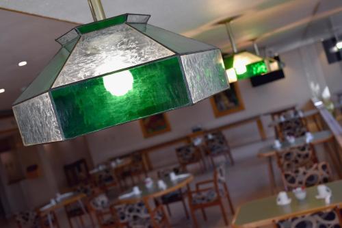a green glass chandelier in a restaurant with tables at HM Mirador in Chihuahua