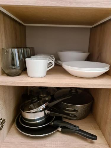 a shelf with bowls and other dishes on it at Chaleureux bel Espace - Confort et Harmonie in Liège