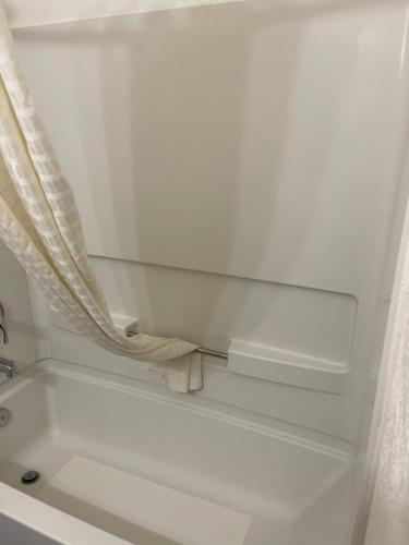 a bath tub with a shower curtain next to a window at Extend-a-Suites Tempe in Tempe