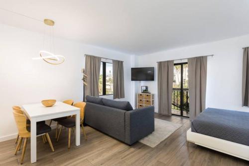 a living room with a bed and a couch and a table at Modern Studio on I-Drive: parking + pool included in Orlando
