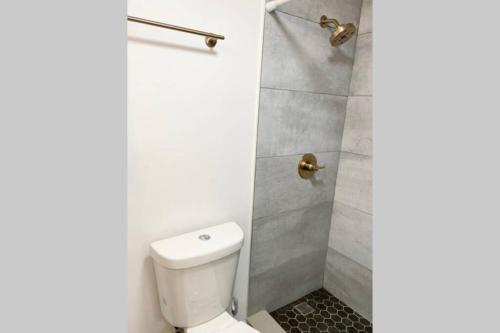 a bathroom with a toilet and a shower at Modern Studio on I-Drive: parking + pool included in Orlando