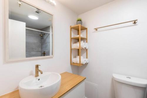 a bathroom with a sink and a toilet and a mirror at Modern Studio on I-Drive: parking + pool included in Orlando