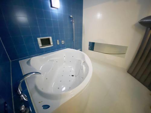 a bathroom with a sink in a blue tiled bathroom at リージェンシー in Takata