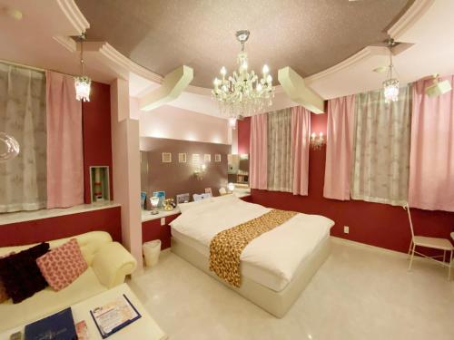 a bedroom with a bed and a chandelier at リージェンシー in Takata