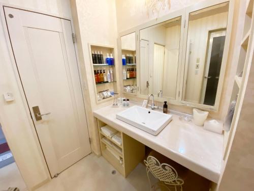 a bathroom with a sink and a mirror at リージェンシー in Takata
