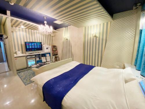 a bedroom with a large white bed and a television at リージェンシー in Takata