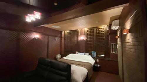 a small room with a bed and a chair at リージェンシー in Takata