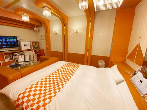 a room with a checkered blanket on a bed at リージェンシー in Takata