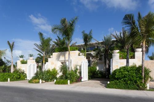 a house with palm trees in front of a street at Villa Sha - Cancun Luxury Beachfront in Cancún