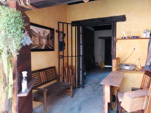 Una habitación con un banco y una mesa y una puerta. en CASA ICHIK ANTIGUA GUATEMALA, en Antigua Guatemala