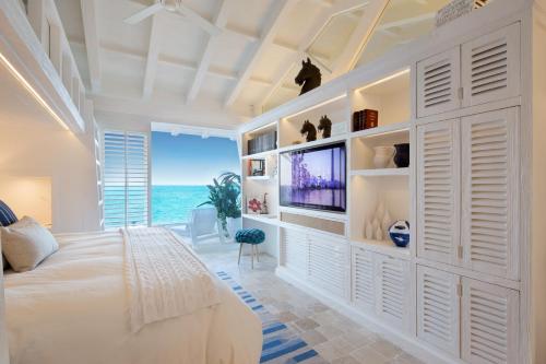 a bedroom with a white wall with a tv at Villa Sha - Cancun Luxury Beachfront in Cancún
