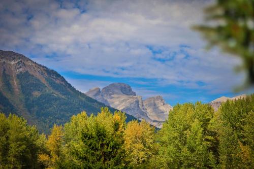 a view of a mountain range with trees in the foreground at Riverside by FantasticStay in Fernie