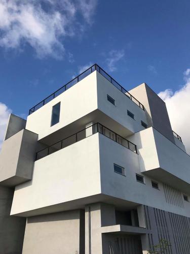a white building with a blue sky in the background at FFF Hotel in Hengchun