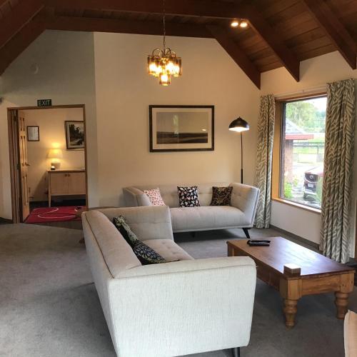 a living room with two couches and a coffee table at Woodland Glen Lodge B&B in Hokitika