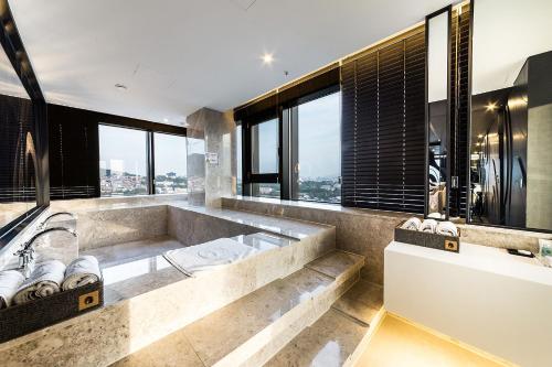 a large bathroom with a large tub and large windows at Hotel The Designers Seoul Station in Seoul