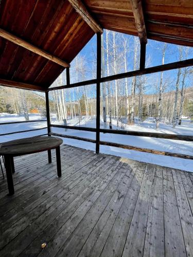 a screened in porch with a bench in the snow at Beyul Retreat in Meredith