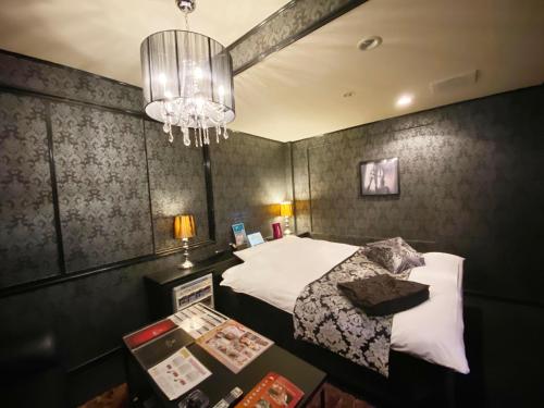 a hotel room with a bed and a chandelier at リバーサイド in Imabari
