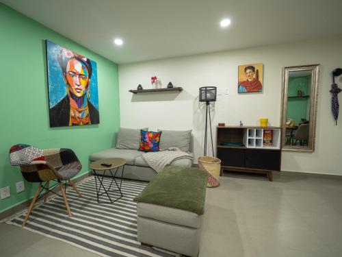 a living room with a couch and a painting on the wall at Taniveths House in Mexico City