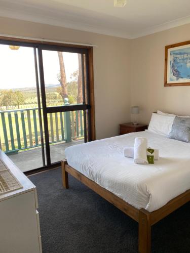 1 dormitorio con cama y ventana grande en Hunter Homestead, Lovedale, en Rothbury