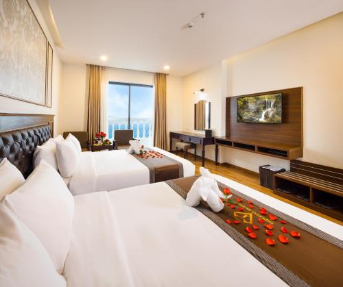 a hotel room with two beds and a piano at Imperial Nha Trang in Nha Trang