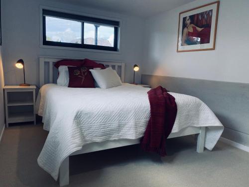 a bedroom with a large white bed with a window at Angasi in Coles Bay