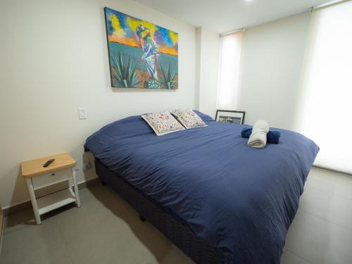 a bedroom with a bed and a painting on the wall at Taniveths House in Mexico City