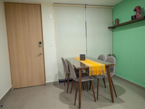 a dining room table with chairs and a yellow napkin on it at Taniveths House in Mexico City