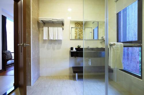 a bathroom with a glass shower and a sink at 雲起軒民宿 Cloudscape B&B in Jian