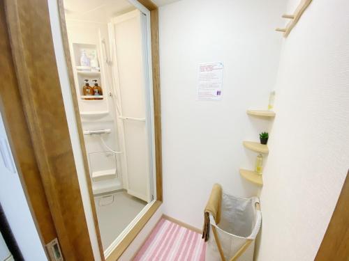 a small bathroom with a shower and a mirror at GuestHouse017徳島個室 飲食街中心 阿波踊り会館7分 文理&徳島大学 アスティとくしま車8分 in Tokushima