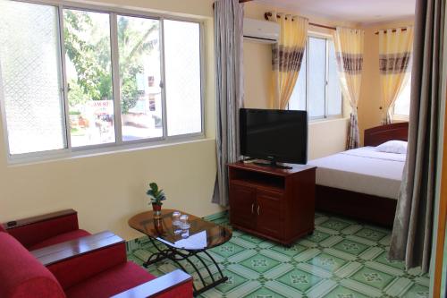 1 dormitorio con 1 cama, TV y sofá en Lam Son Hotel, en Vung Tau