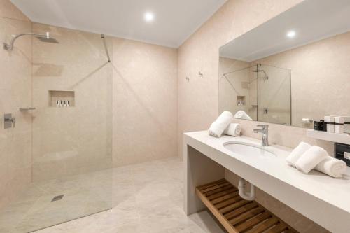 a bathroom with a sink and a shower at Canterbury International Hotel in Forest Hill