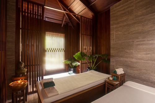 a bedroom with a bed and a window with a plant at Sea Shell Resort & Spa, Havelock in Havelock Island
