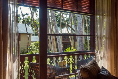 a window of a balcony with a view of trees at Sea Shell Resort & Spa, Havelock in Havelock Island