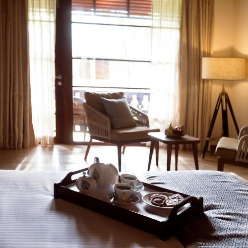 a tray with a tea set on top of a bed at Sea Shell Resort & Spa, Havelock in Havelock Island