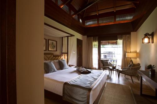 a bedroom with a large bed and a living room at Sea Shell Resort & Spa, Havelock in Havelock Island