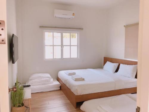 a bedroom with two beds and a window at Stayokay Sattahip - Flat House in Sattahip