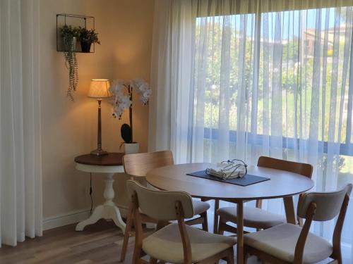 a dining room with a table and chairs and a window at Abalone Guest Accommodation in Lakes Entrance