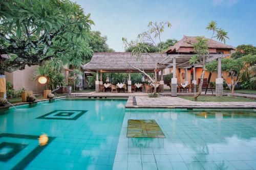 a swimming pool in front of a villa at Visakha Sanur by Puri Signatures in Sanur