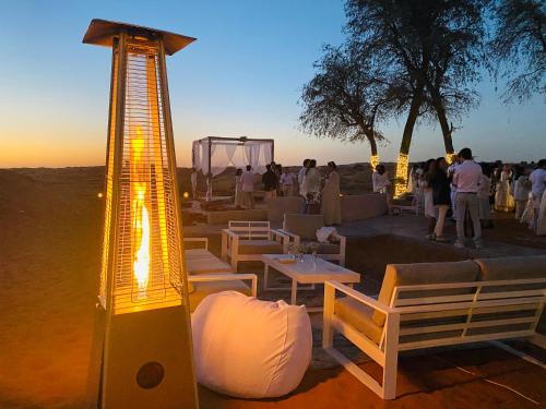 a group of people standing in the desert with a light at Bedouin Oasis Desert Camp- Ras Al Khaimah in Ras al Khaimah