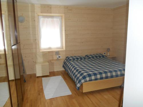 - une petite chambre avec un lit et une fenêtre dans l'établissement CASA CAMPAGNA, à Cavalese