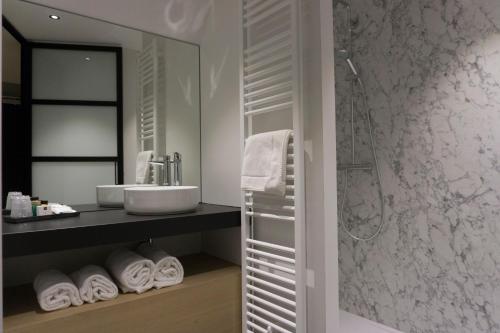 La salle de bains est pourvue d'un lavabo et d'une douche. dans l'établissement Hotel Central, à Roosendaal