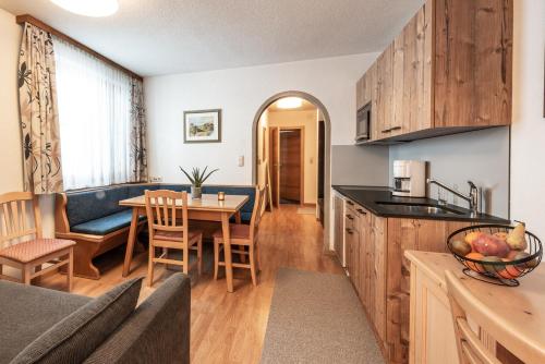 eine Küche und ein Wohnzimmer mit einem Tisch und Stühlen in der Unterkunft Dà Ingo - Apartments & More in Damüls