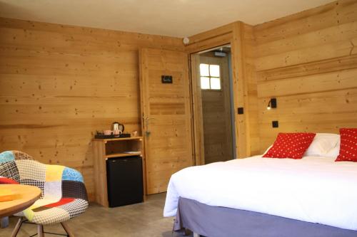 a bedroom with wooden walls and a bed and a table at Chalet du Bersend in Beaufort