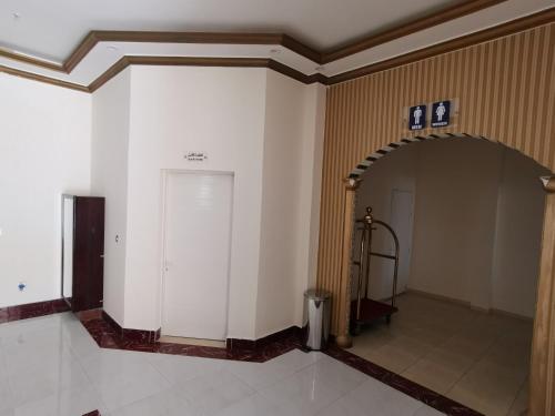 a hallway with a white wall and an archway at Address hotel Apartments العنوان للشقق الفندقية in Aş Şa‘arah