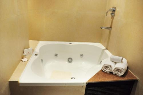 a bath tub in a bathroom with towels on a counter at Hotel Senses in Kolkata