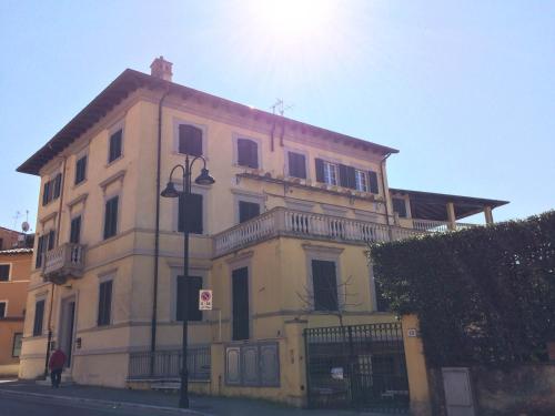 a large yellow building on the side of a street at Le Camere Pietrasantine - Centro Storico in Pietrasanta
